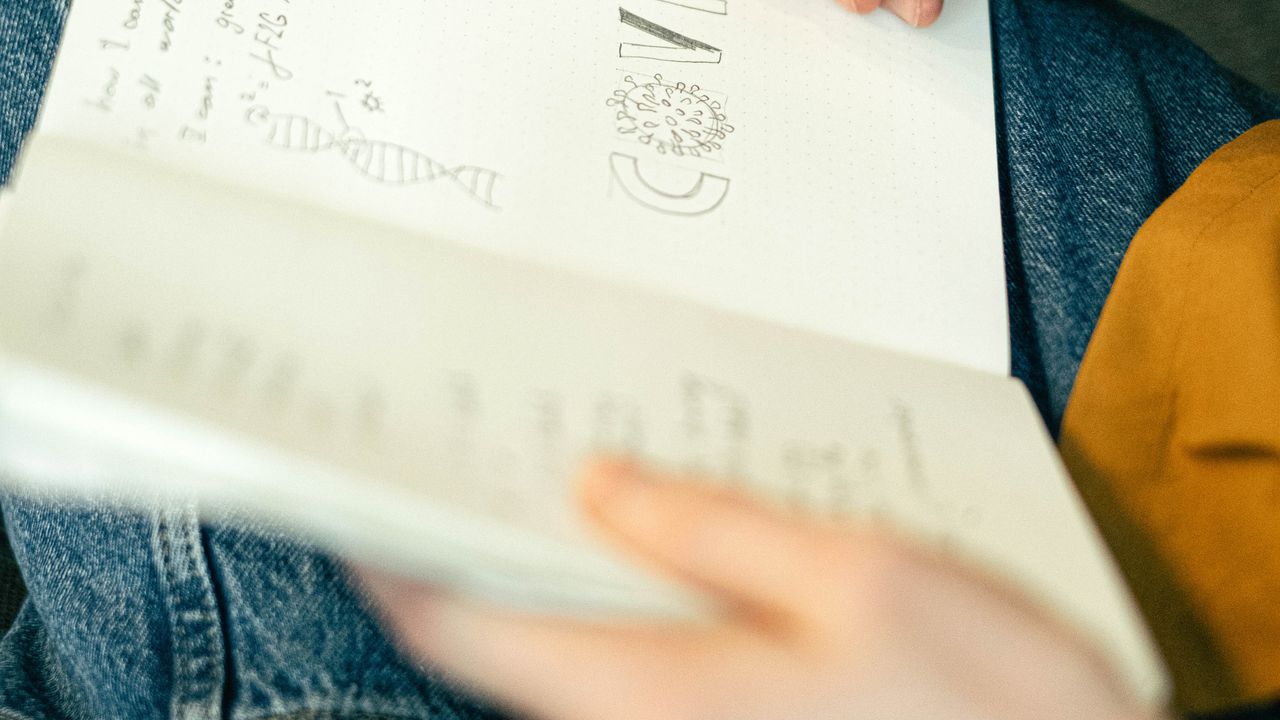 Hand skizziert Logo-Ideen mit Stift in einem Notizbuch