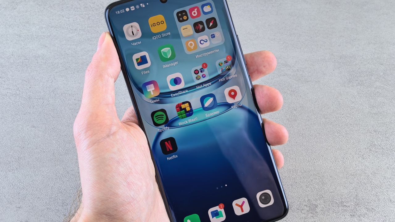 Hand hält ein Smartphone mit App-Symbolen