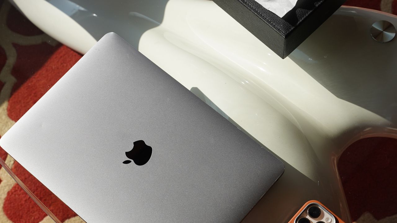 Laptop und Smartphone nebeneinander auf einem modernen Arbeitsplatz