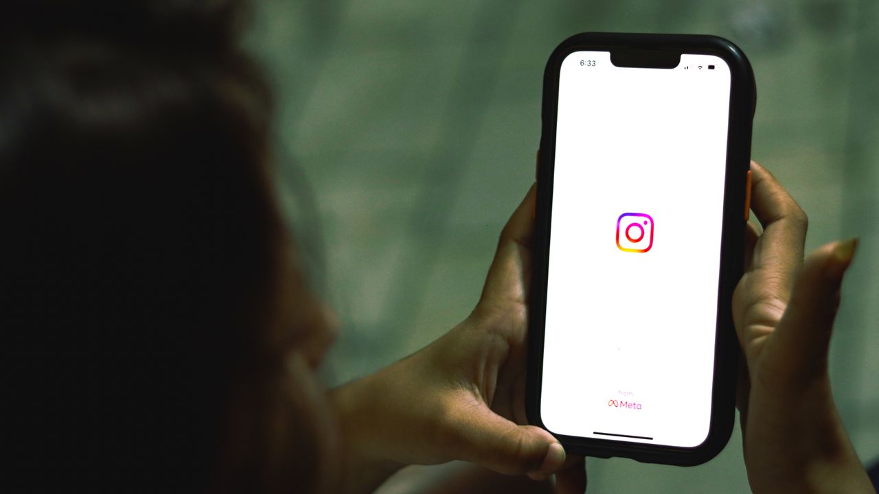 Hand hält ein Smartphone mit geöffneter Social-Media-App